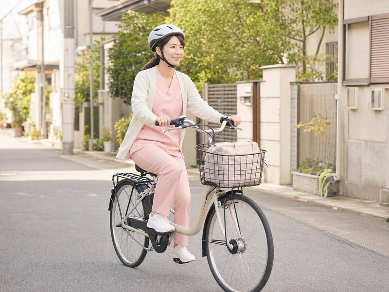 訪問看護師が電動自転車で住宅街を移動している様子