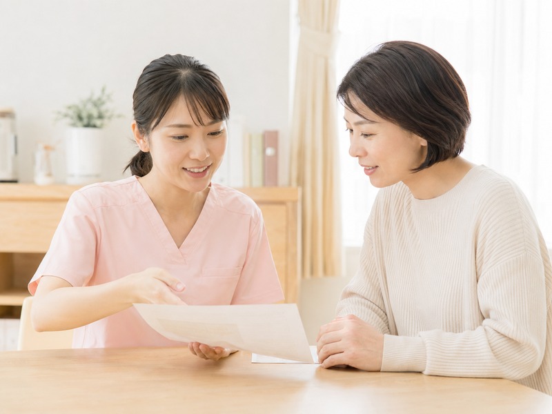 スタッフが応募検討者からの質問に資料を見せながら答えている様子