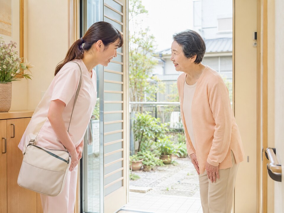 訪問看護師が訪問先の玄関先で利用者と挨拶している様子