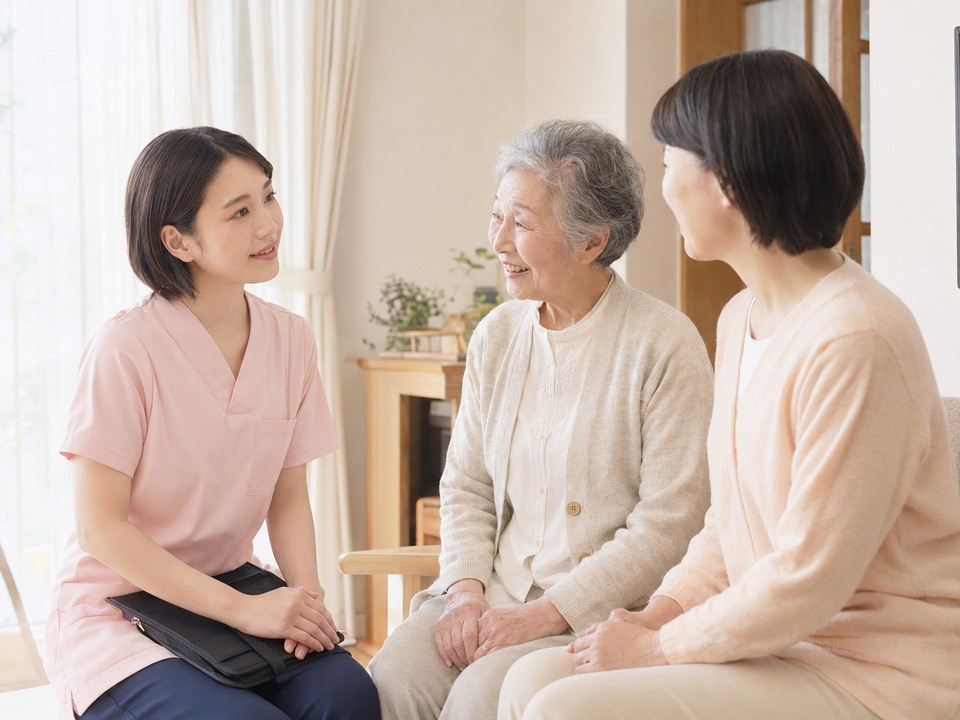 訪問看護師が利用者宅で利用者やご家族と会話している様子